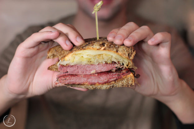 Stock Photography, first bite of reuben sandwich, lunch time, reuben sandwich, restaurant food, man eating lunch, man eating reuben sandwich, meal time